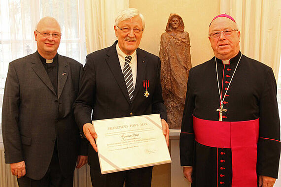 Der Präsident des Bonifatiuswerkes der deutschen Katholiken, Heinz Paus, empfing aus der Hand von Erzbischof Hans-Josef Becker die Ernennungsurkunde zum „Ritter des Ordens vom Heiligen Papst Silvester“ und den dazugehörigen Orden. V.l.n.r.: Generalvikar Alfons Hardt, Heinz Paus, Erzbischof Hans-Josef Becker. Foto: pdp - Erzbistum Paderborn 