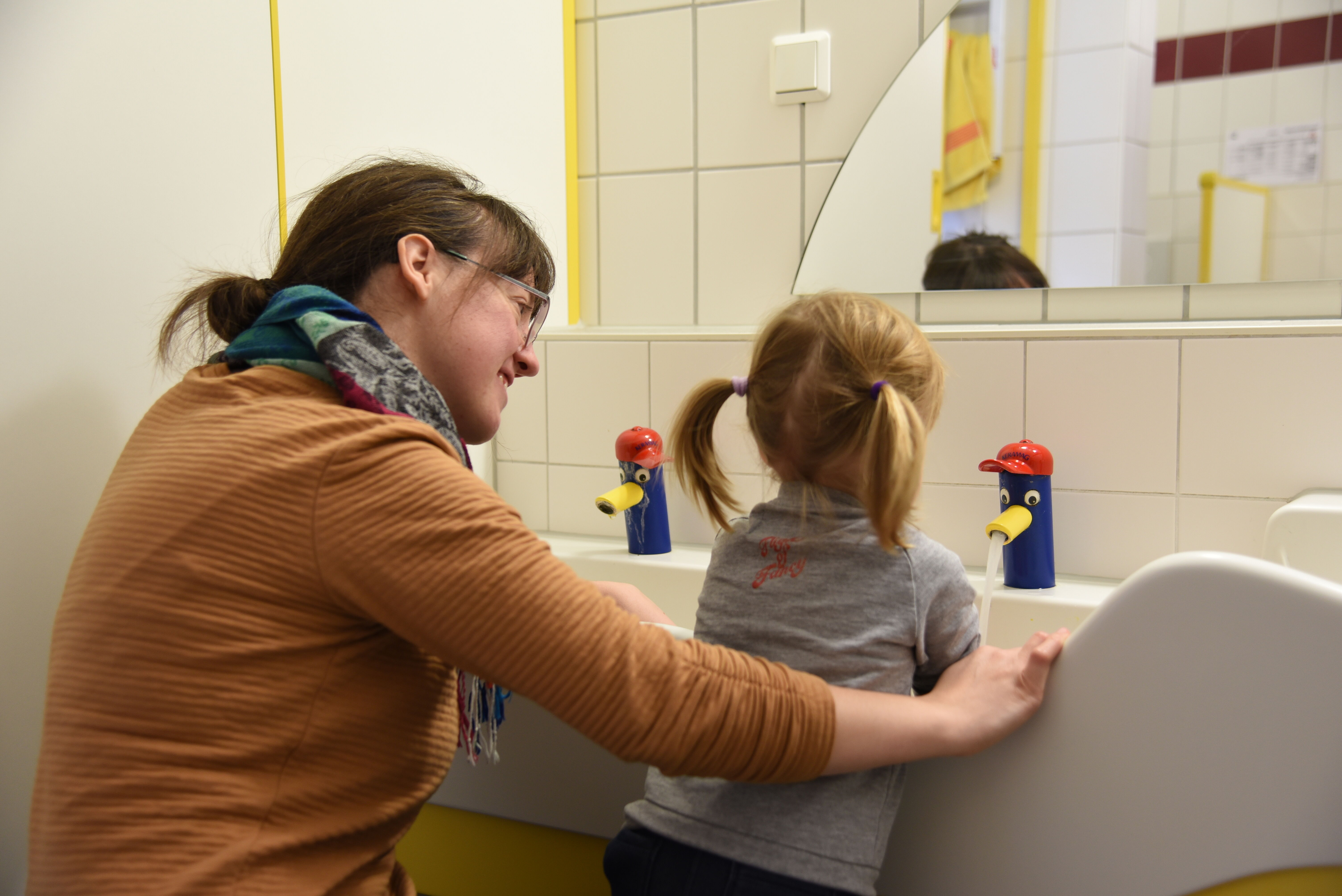 Haus Teresa: Eine Mitarbeiterin hilft beim Händewaschen im Kleinkindbereich. Foto: S. Helmers