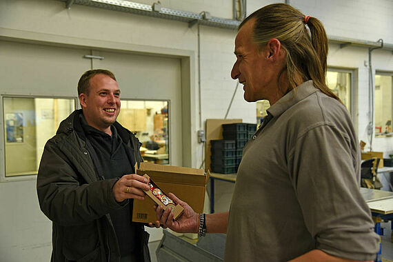 Mirko Wiedeking (links) schenkt einem Inhaftierten einen Schoko-Nikolaus. (Foto: Sr. Theresita M. Müller)