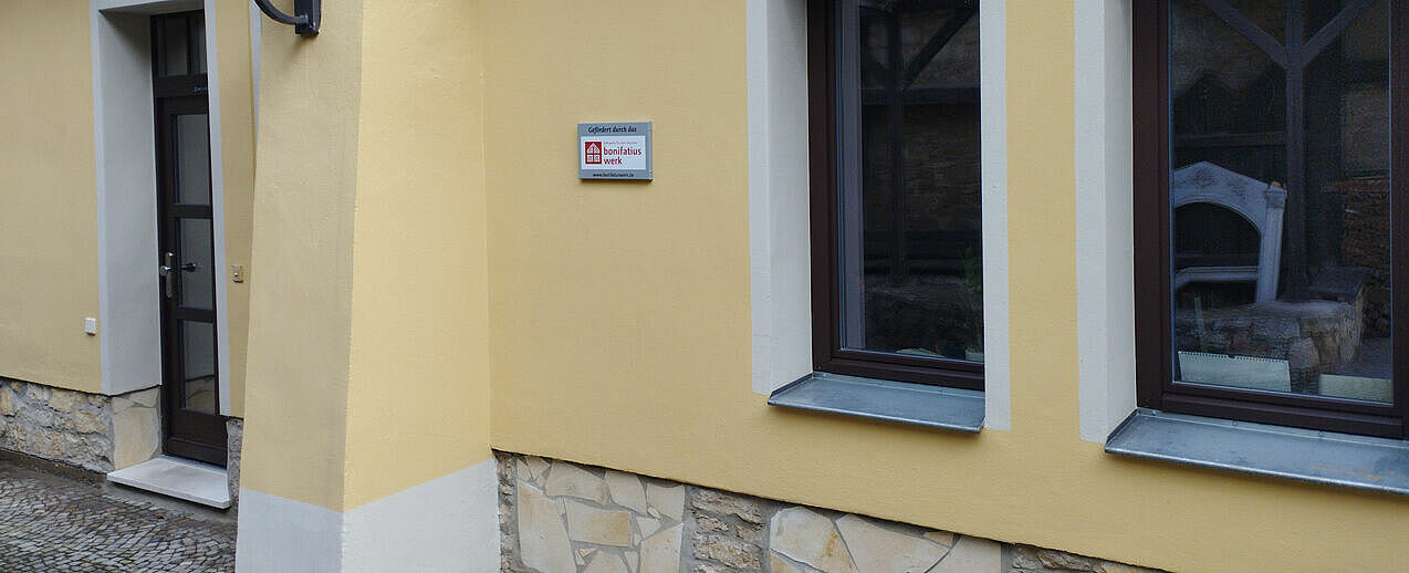 Das Schild "Gefördert durch das Bonifatiuswerk" wurde nach dem Abschluss der Sanierungsarbeiten am Eingang angebracht. (Foto: Gemeinde St. Peter und Paul)
