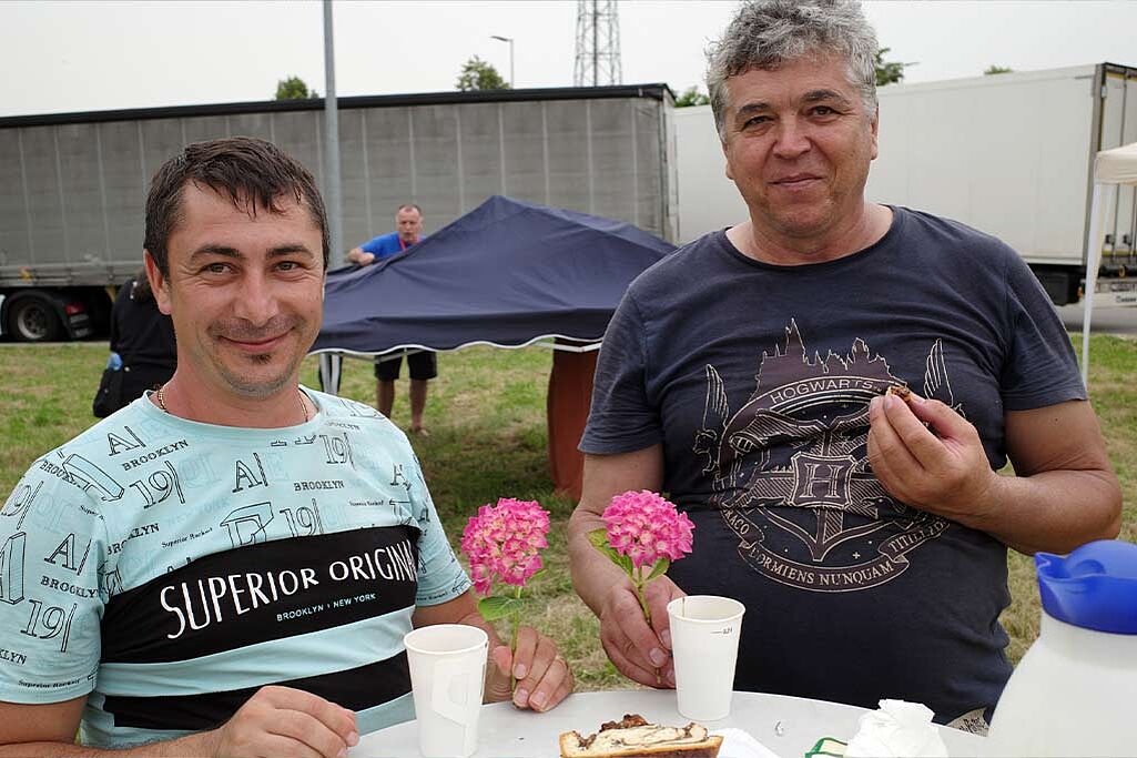 	Diese beiden Fernfahrer freuen sich über das Sommerfest am Rastplatz - eine willkommene Ablenkung. Foto: Betriebsseelsorge Bodensee-Hohenzollern, Erzdiözese Freiburg