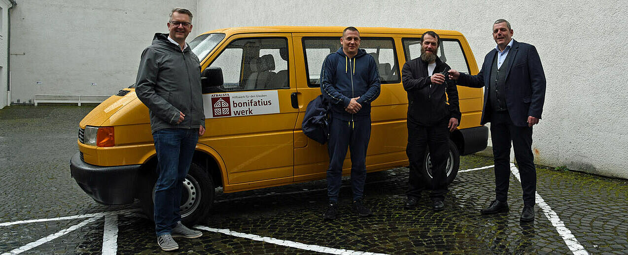 Ingo Imenkämper, Geschäftsführer des Bonifatiuswerkes, (rechts) und Thomas Twents, Bereichsleiter Projektverwaltung, (links) überreichten Pfarrer Mariusz Kempa (zweiter von rechts) und Arnis Malzubris den Autoschlüssel für den BONI-Bus. (Foto: Simon Helmers)
