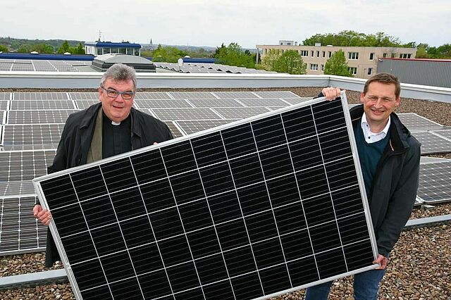 Monsignore Georg Austen, Generalsekretär des Bonifatiuswerkes und Dr. Andreas Schmitt, Geschäftsführer bei WestfalenWIND zeigen ein Photovoltaik-Panel, wie es auf der Fazenda da Esperança installiert werden soll. (Foto: Patrick Kleibold)