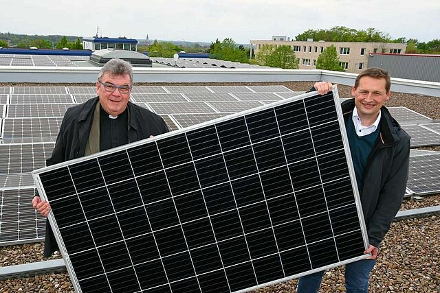 Monsignore Georg Austen, Generalsekretär des Bonifatiuswerkes und Dr. Andreas Schmitt, Geschäftsführer bei WestfalenWIND zeigen ein Photovoltaik-Panel, wie es auf der Fazenda da Esperança installiert werden soll. (Foto: Patrick Kleibold)
