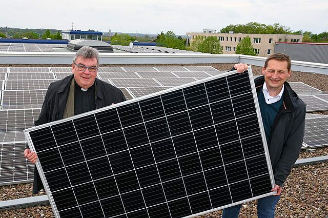 Monsignore Georg Austen, Generalsekretär des Bonifatiuswerkes und Dr. Andreas Schmitt, Geschäftsführer bei WestfalenWIND zeigen ein Photovoltaik-Panel, wie es auf der Fazenda da Esperança installiert werden soll. (Foto: Patrick Kleibold)