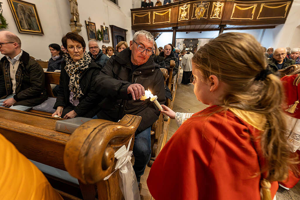 Als Zeichen der Hoffnung geben die Messdiener das Licht der Osterkerze an die Gemeinde weiter