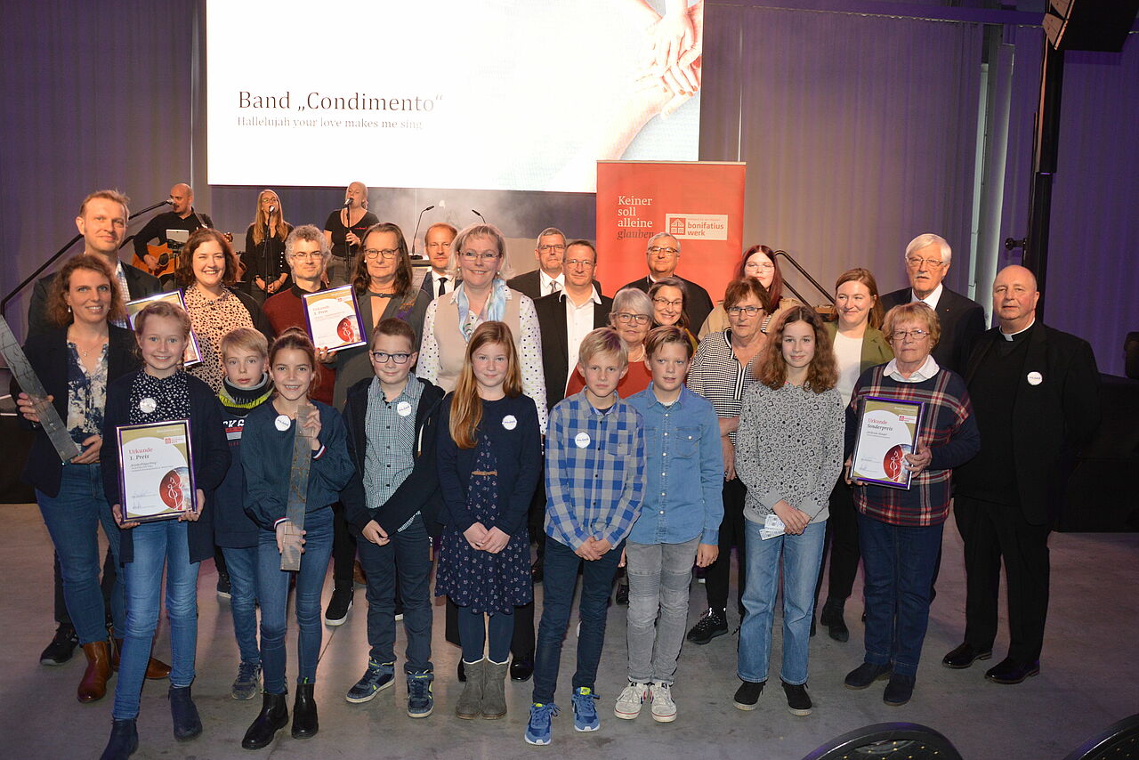 Das Foto zeigt die Preisträger mit Speyers Bischof Dr. Karl-Heinz Wiesemann (9. von rechts), der stellvertretenden rheinland-pfälzischen Ministerpräsidentin Katharina Binz (4. von rechts) und Bonifatiuswerk-Präsident Heinz Paus (3. von rechts). Foto: Bonifatiuswerk/Marius Thöne