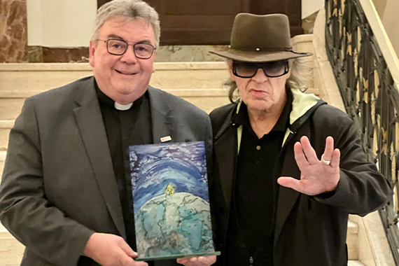 Monsignore Georg Austen (links) und der Künstler Udo Lindenberg mit einer Miniatur-Glasbild des Kunstwerkes "Dach der Welt". (Foto: privat)