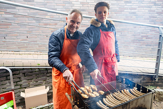 Ehrenamtliche Helfer grillen Würstchen für Besucher der Suppenküche. (Foto: Veronika Gaffron)