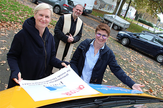 Sichtbare Kooperation - Mandy Jost (v.l.) und Sandra Nitsche bringen die Logos von Parea und „Familie mittendrin“ auf dem Boni-Bus an. (Bild: kathma/Schuhmann)