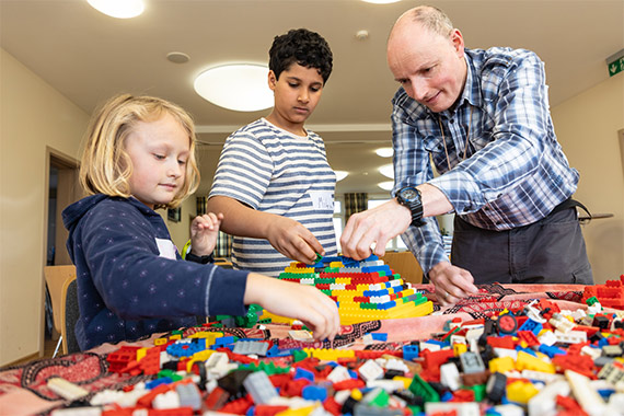 Mit Fantasie: Julie (7) und Mika (8) bauen gemeinsam mit Gemeindereferent Christof Stracke Pyramiden aus Lego-Steinen. (Foto: Hartmut Salzmann