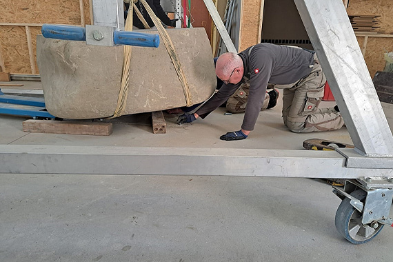 Langsam und präzise wurde der Taufstein in der Kirche platziert. (Foto: Familienzentrum Kloster Kerbscher Berg)